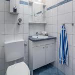 Badezimmer mit Toilette, Waschbecken und Duschmöglichkeit.