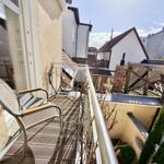 Terrasse mit Stuhl und Blick auf Dächer und Bäume