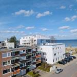 Wohnhaus mit Blick auf Strand und Meer unter blauem Himmel.