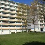 Hochhaus mit Balkonen und grünem Rasen vorne