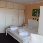 Schlafzimmer mit Doppelbett, Kleiderschrank und Wandbildern