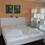 Schlafzimmer mit Doppelbett, weißen Möbeln und Wandbildern von Schafen.