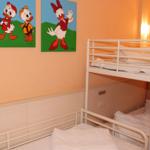 Zimmer mit Doppelstockbett und Wandbildern von Entenfiguren.