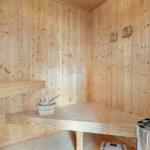Sauna mit Holzwand, Sitzbank und Holzschale.