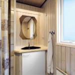 Badezimmer mit Holzwand, Waschbecken, Spiegel und Fenster