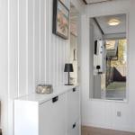 Hallenraum mit Schrank, Spiegel und Regal. Holzboden und weiße Wände.