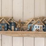 Holzdekoration mit Häusern und Strand-Schild an Wand