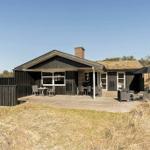 Haus mit Terrasse, Grill und Sitzgelegenheiten in Grashügeln