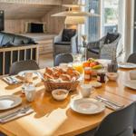 Esstisch mit Frühstück, Kamin und Wohnbereich mit Sofa und TV.