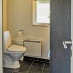 Toilettenraum mit Toilette, Heizkörper und Fenster