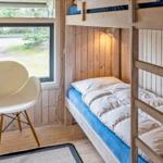 Zimmer mit Kletterbett, weiße Sitzgelegenheit und Fensterblick.