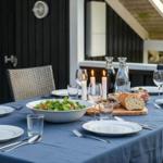 Gedeckter Tisch mit Salat, Brot und Kerzen auf Terrasse