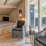 Schlafzimmer mit Doppelbett, zwei Sessel und Blick auf Terrasse.