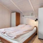 Schlafzimmer mit Holzwand, Bett und Schränken