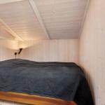 Schlafzimmer mit Holzwand und Bett unter Dachschräge