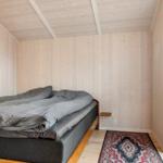 Schlafzimmer mit Holzwänden, Bett und Fenster