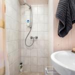 Badezimmer mit Dusche, Waschbecken und Handtuch.