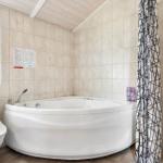 Bad mit Whirlpool, Toilette und Fenster mit beschichtetem Glas.