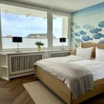 Schlafzimmer mit Bett, Fenster und Wand mit Fischmotiv.