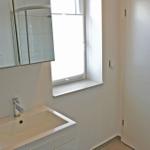 Badezimmer mit Waschbecken, Spiegel und Dusche