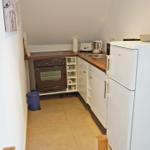 Küche mit Kühlschrank, Herd und Spüle.