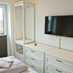 Schlafzimmer mit Bett, Schrank, TV und Fenster.