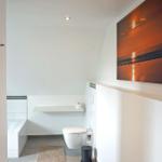 Badezimmer mit Toilette, Badewanne und Wandbild