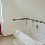 Bad mit Dusche und Fenster mit rotem Jalousie
