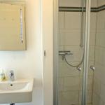 Badezimmer mit Dusche und Spiegelschrank mit LED-Beleuchtung.