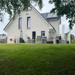 Modernes Haus mit großem Garten und Außensitzgelegenheit.