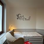 Bedroom with bed, window, and wall decoration Carpe Diem.
