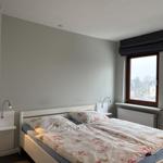 Bedroom with bed, nightstands, and window. Bed with floral bedding.
