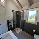 Badezimmer mit Dusche, Badewanne und Fensterblick