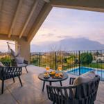 Terrasse mit Sitzgelegenheiten und Poolblick auf Berge