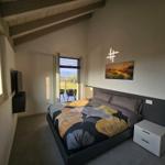 Schlafzimmer mit Bett, TV und Balkonansicht.