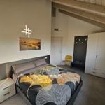 Schlafzimmer mit Bett, Kleiderschrank und Fenster