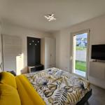 Schlafzimmer mit Bett, TV und Fenster zum Garten.