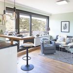 Moderne Küche mit Sitzgelegenheit und Wohnbereich mit Sofa und Sessel.