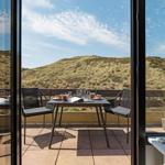 Terrasse mit Tisch und Stühlen bietet Aussicht auf Hügel.