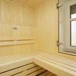 Holzsauna mit Sitzbänken und Fenster zur Aussicht.