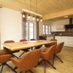 Essbereich mit Holztisch und braunen Stühlen unter Holzdecke