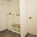 Eingangsbereich mit Schuhschrank und Willkommensschild