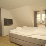 Schlafzimmer mit Doppelbett, TV und zwei Fenstern mit Blick.