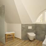 Badezimmer mit Dusche, Toilette und Waschbecken unter Dachschräge mit Fenster.