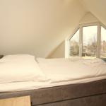 Schlafzimmer mit Doppelbett und großem Fenster zur Aussicht