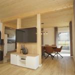 Wohn- und Essbereich mit Holzdecke, Kamin und TV.
