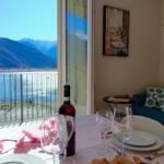 Tisch mit Wein und Blumen vor Balkon mit Bergblick
