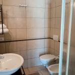 Badezimmer mit Toilette, Waschbecken und Dusche.
