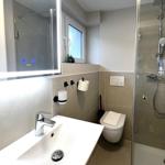 Badezimmer mit Dusche, WC und Waschbecken mit Spiegel.
