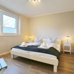 Schlafzimmer mit Bett, Nachttischen und Fenster